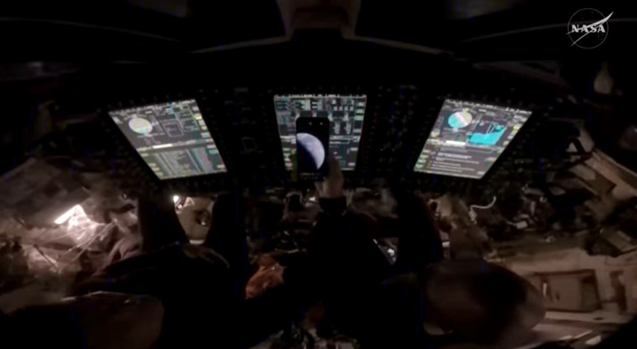 NASA astronauts Reid Wiseman and Victor Glover show a photo of Earth taken just moments after the Orion spacecraft ignited its thrusters for a final burn for 8 seconds, pushing Artemis II toward Earth. Credit: NASA