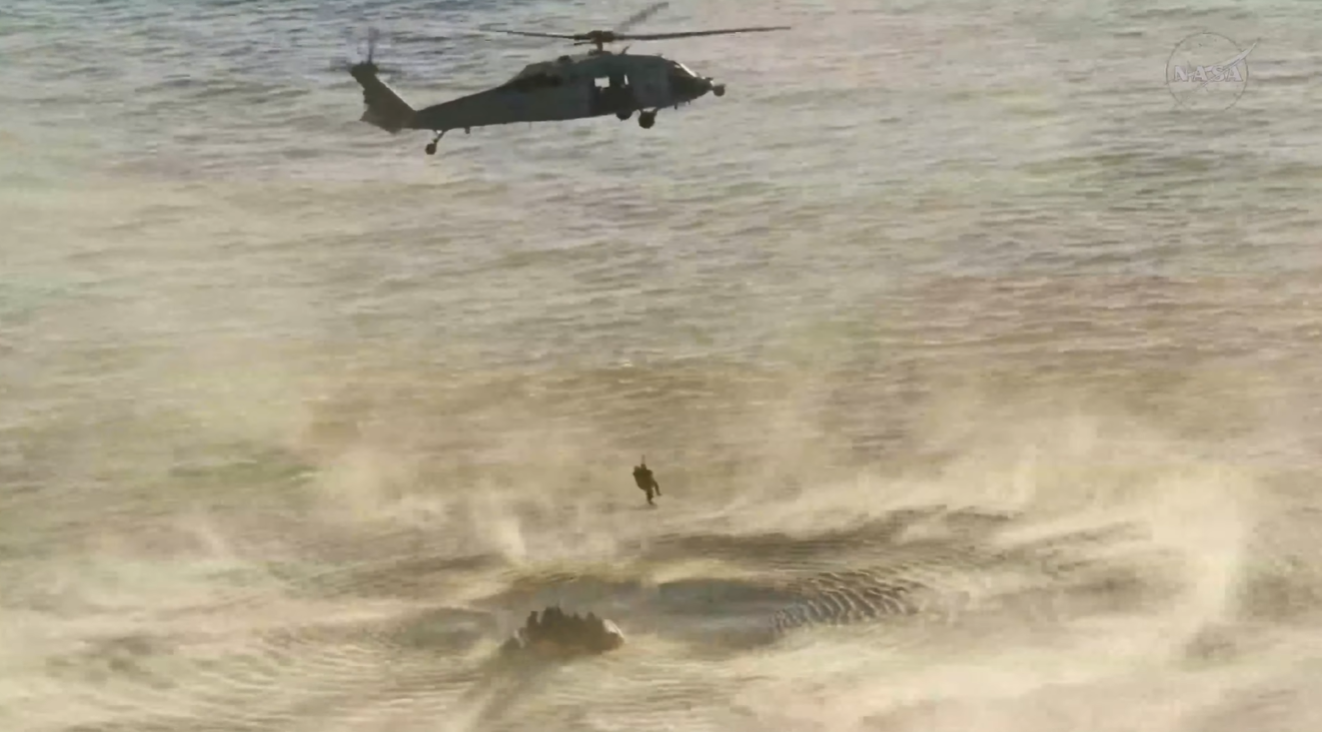 Artemis II görevi uzmanı ve NASA astronotu Christina Koch, USS John P. Murtha gemisine götürülmeden önce ABD Donanması'na ait bir helikoptere bindiriliyor.