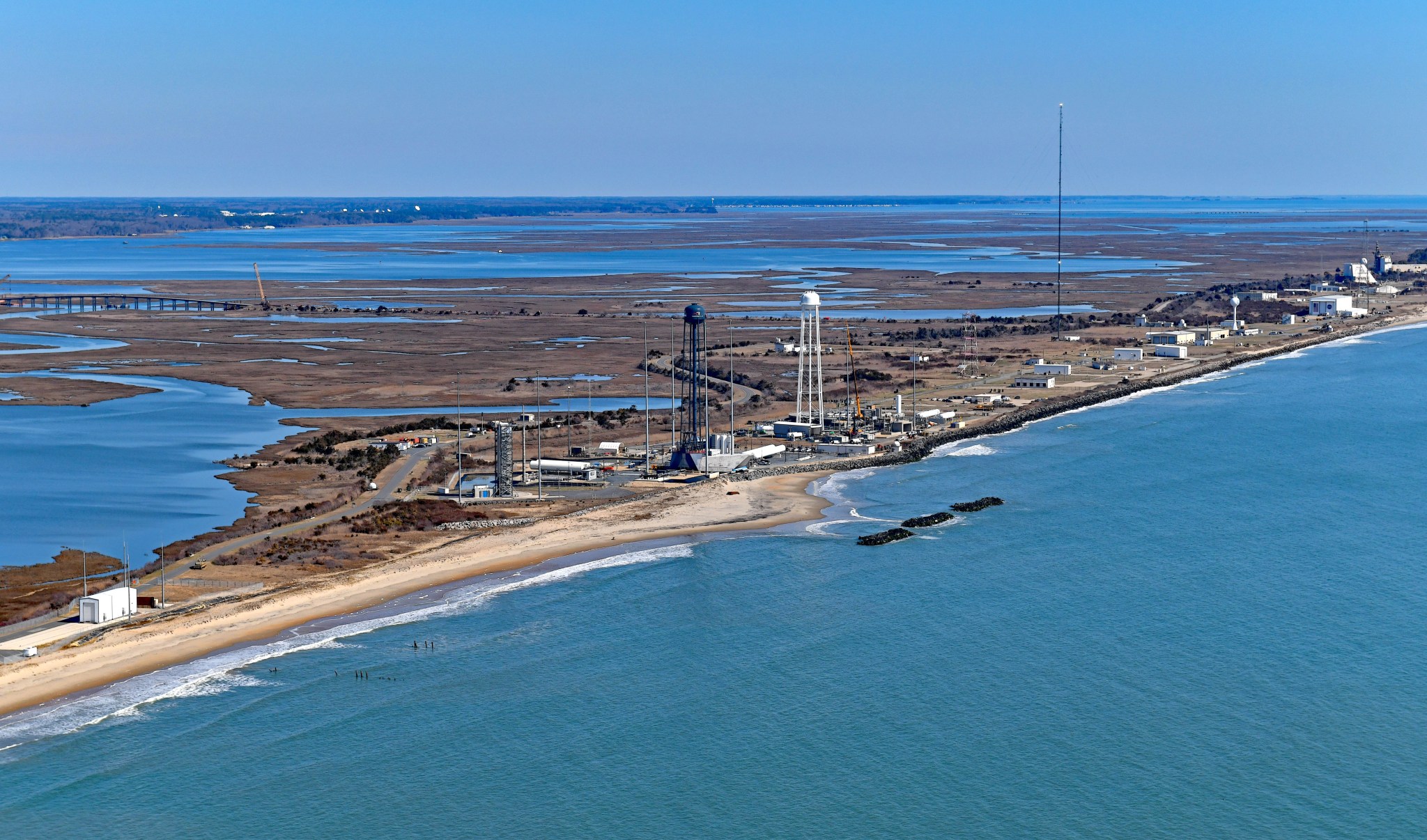 Aerial view of NASA's Wallops Flight Facility's launch range structures along the coastline of Wallops Island, Virginia. Ocean, bay and marsh lands surround the range.