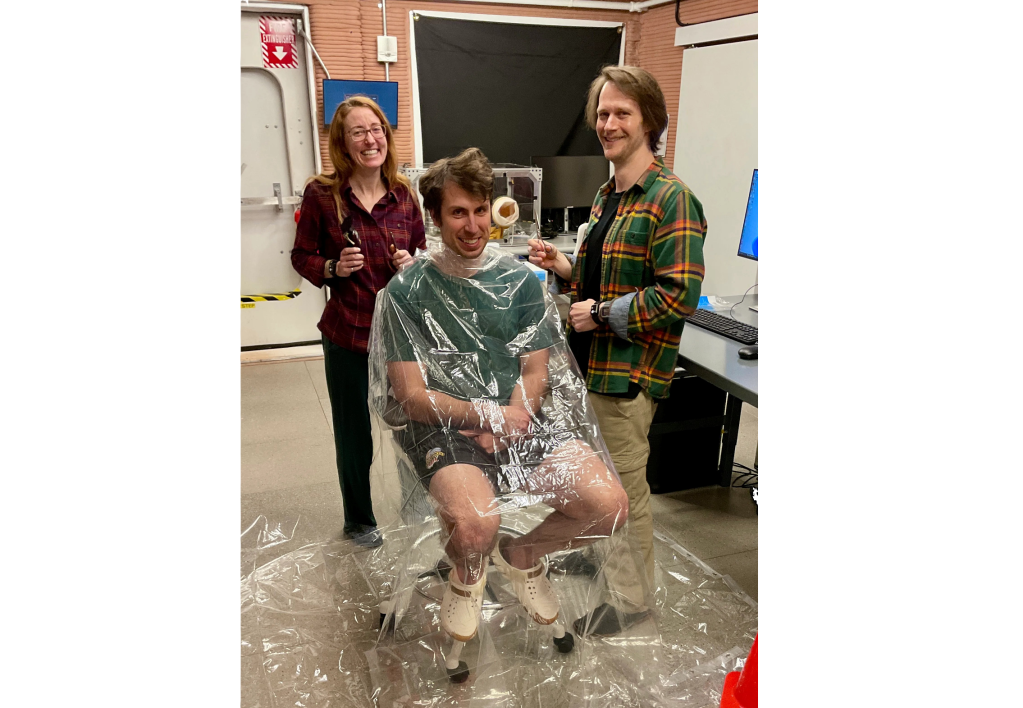 Ross Elder, Crew Health and Performance Exploration Analog (CHAPEA) Mission 2 commander, receiving a haircut from Ellen Ellis (left), CHAPEA mission 2 medical officer, and Matthew Montgomery (right), CHAPEA mission 2 science officer.