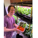 Matthew Montgomery, Crew Health and Performance Exploration Analog (CHAPEA) Mission 2 science officer, showcases vegetables collected during a recent harvest from the hydroponic crop growth system!