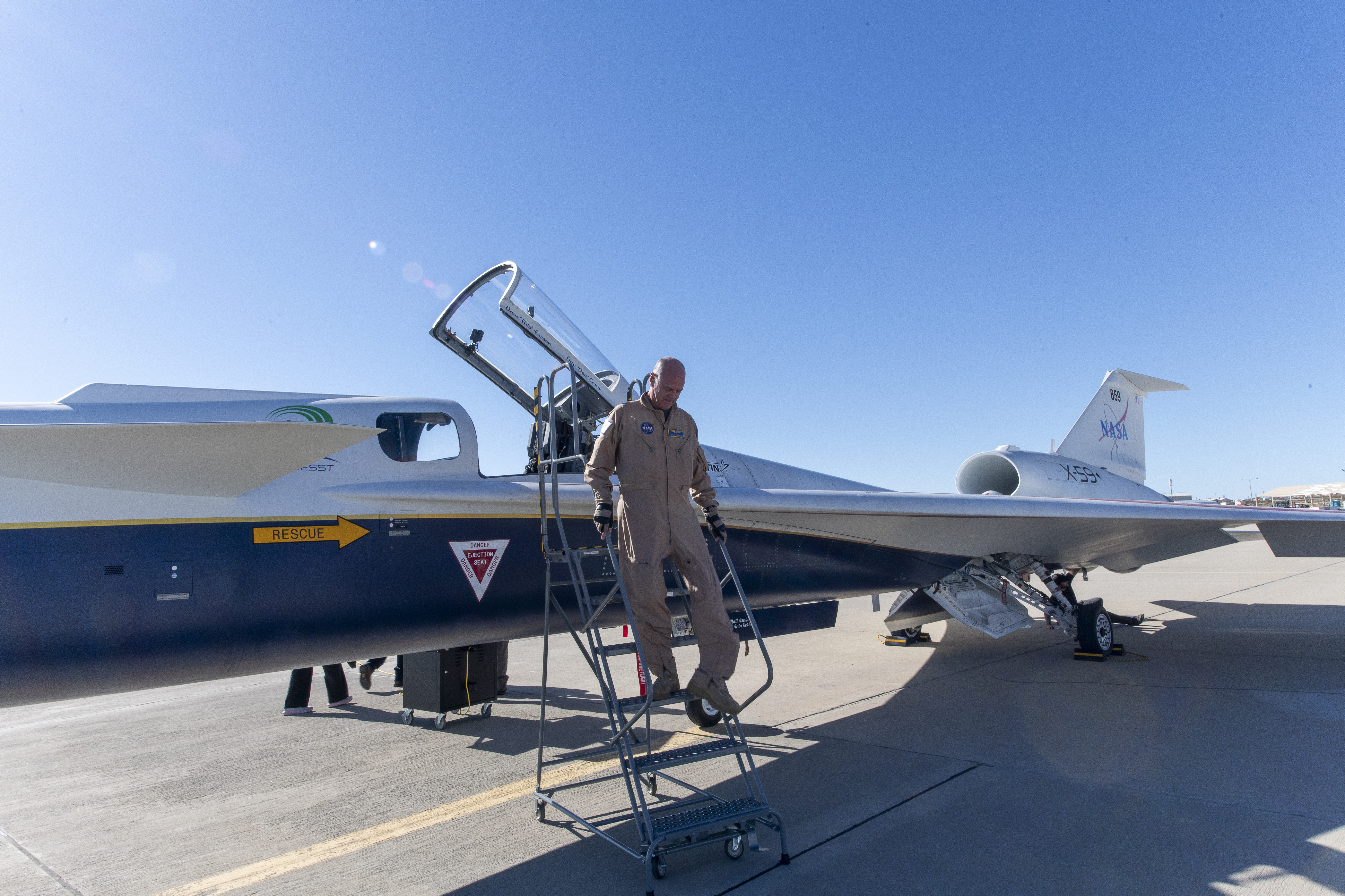 NASA test Pilot Nils steps down from the X-59 cock-pit onto a step ladder.