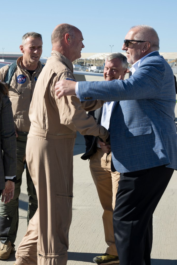 Bob Pearce greeting NASA test pilot Nils Larson with a handshake.