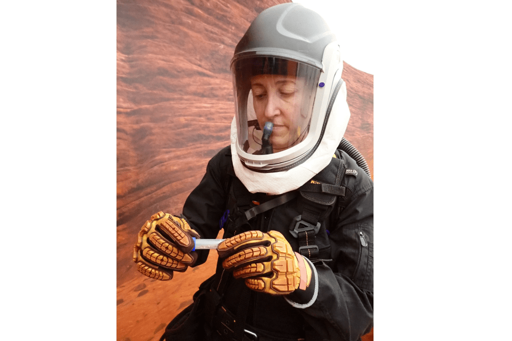 CHAPEA mission 2 medical officer Ellen Ellis collects samples during an extravehicular activity, also known as a spacewalk.