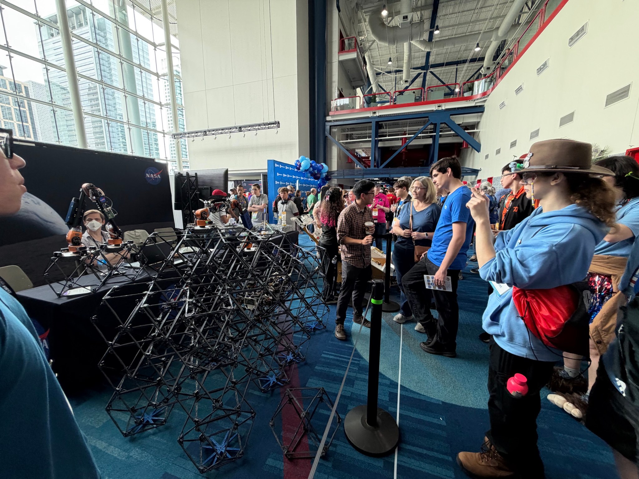 Students at the 2026 FIRST Robotics Championship take pictures of an ARMADAS display in the NASA exhibit.