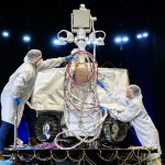 Two technicians in clean room attire work on NASA’s VIPER (Volatiles Investigating Polar Exploration Rover) during testing inside a chamber at NASA’s Johnson Space Center in August 2024.