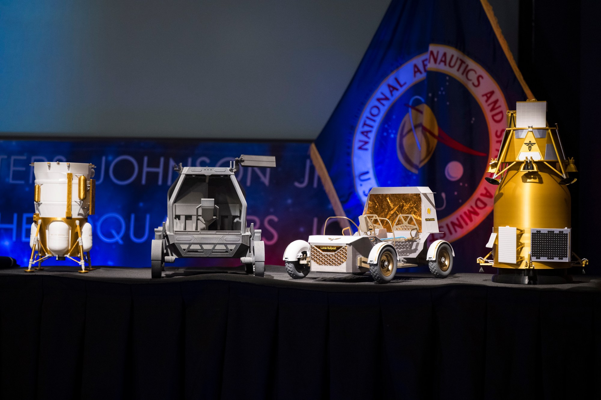 From left to right, models of the Blue Origin Mark 1 Lunar Lander, Astrolab Crewed Lunar Rover, Lunar Outpost Pegasus rover, and the Firely Elytra Dark orbiter are seen at the conclusion of a news conference to discuss Moon Base, a long-term lunar exploration and infrastructure initiative designed to enable sustained human presence and expanded scientific and commercial activity at the lunar South Pole, Tuesday, May 26, 2026, at the Mary W. Jackson NASA Headquarters building in Washington. Photo Credit: (NASA/Aubrey Gemignani)