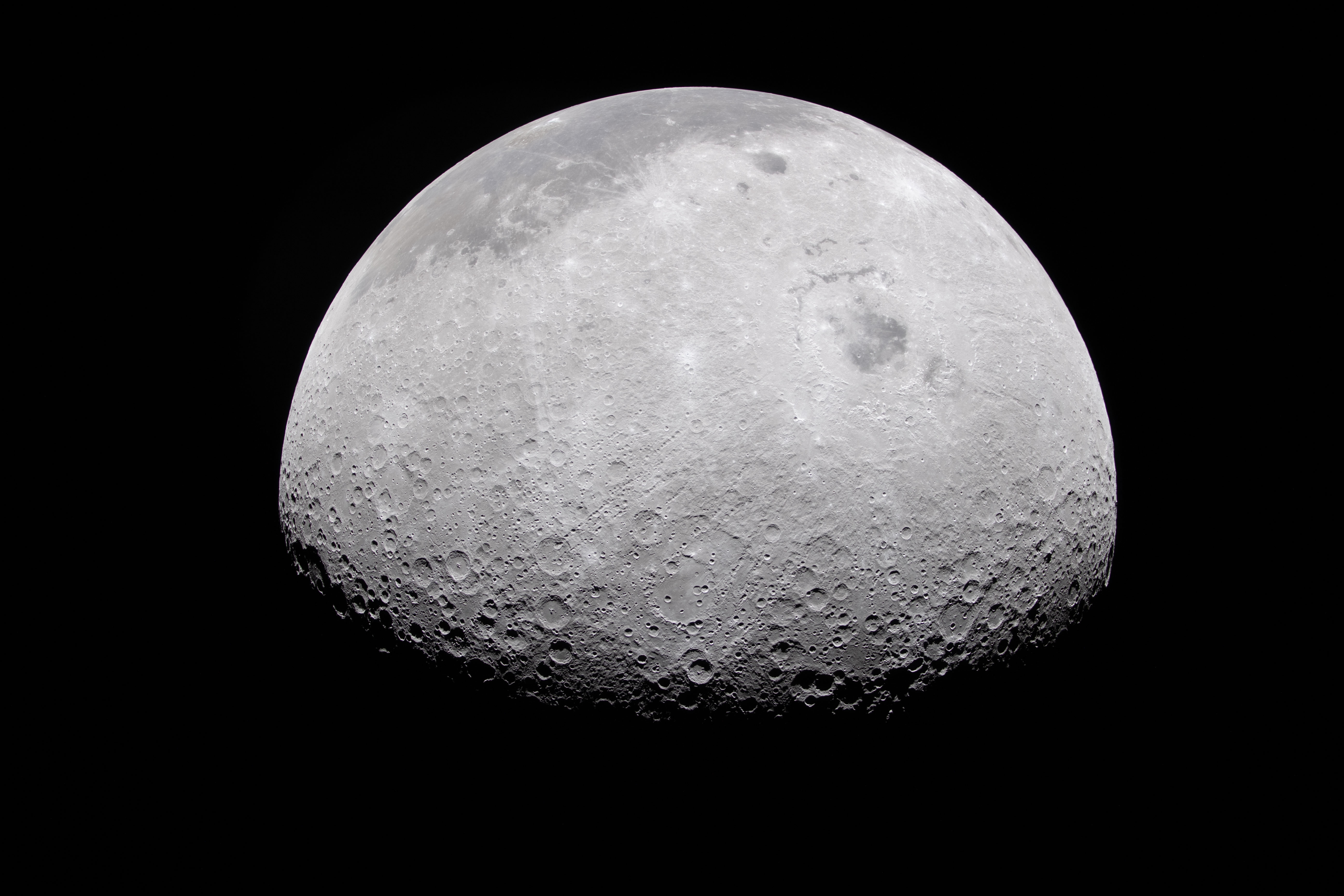 The Moon's rugged surface is on display in this image. Most of the Moon is visible, with the bottom of the sphere disappearing into the darkness. This line between light and dark is called the terminator. The terminator is lined with many craters.