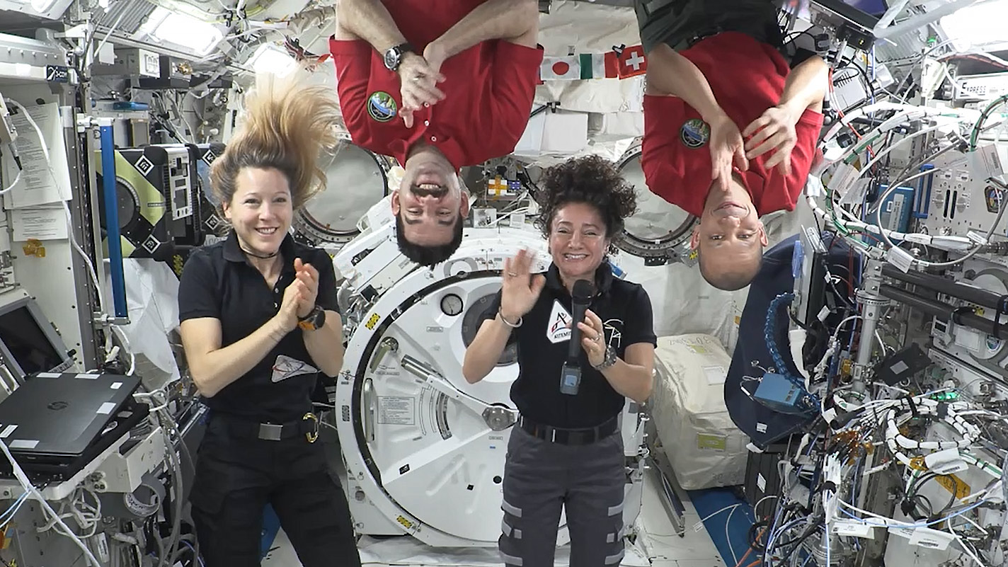 Expedition 74 crew members (from left) Sophie Adenot, Jack Hathaway, Jessica Meir, and Chris Williams congratulate the Artemis III crew in a recorded video message.