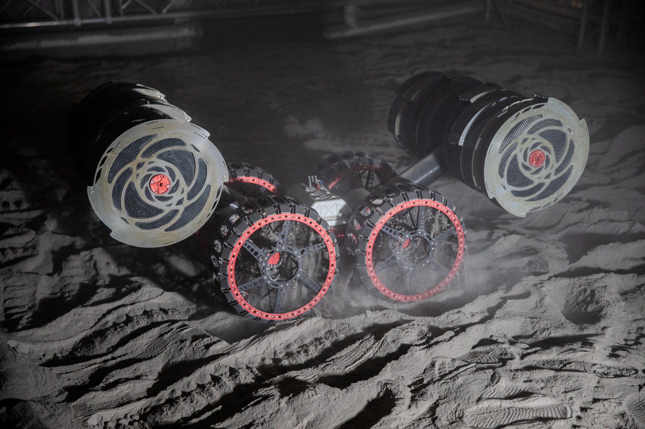 With the lights out, the ISRU Pilot Excavator digs in regolith bin during testing inside Swamp Works at NASA’s Kennedy Space Center in Florida on July 28, 2022. Tests use a gravity assist offload system to simulate reduced gravity conditions found on the Moon. On the surface of the Moon, mining robots like the Pilot Excavator will excavate the regolith and take the material to a processing plant where usable elements such as hydrogen, oxygen and water can be extracted for life support systems. The Pilot Excavator can scoop up icy regolith which can be used to make operations on the Moon sustainable.