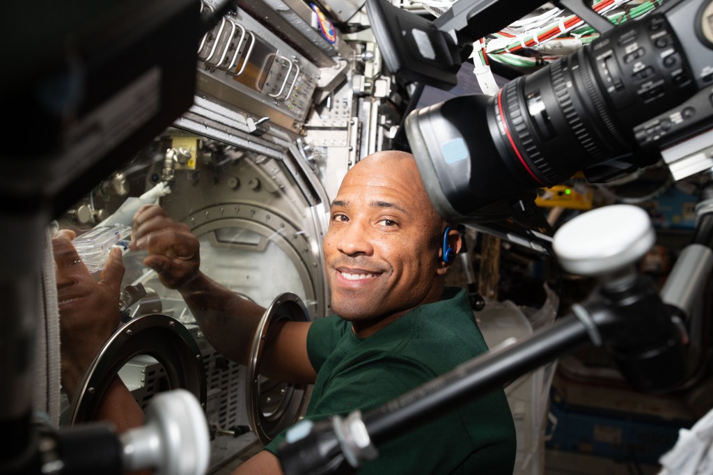 Astronaut Victor Glover performs a sample exchange in the Microgravity Science Glovebox (MSG) as part of the Fiber Optic Production.