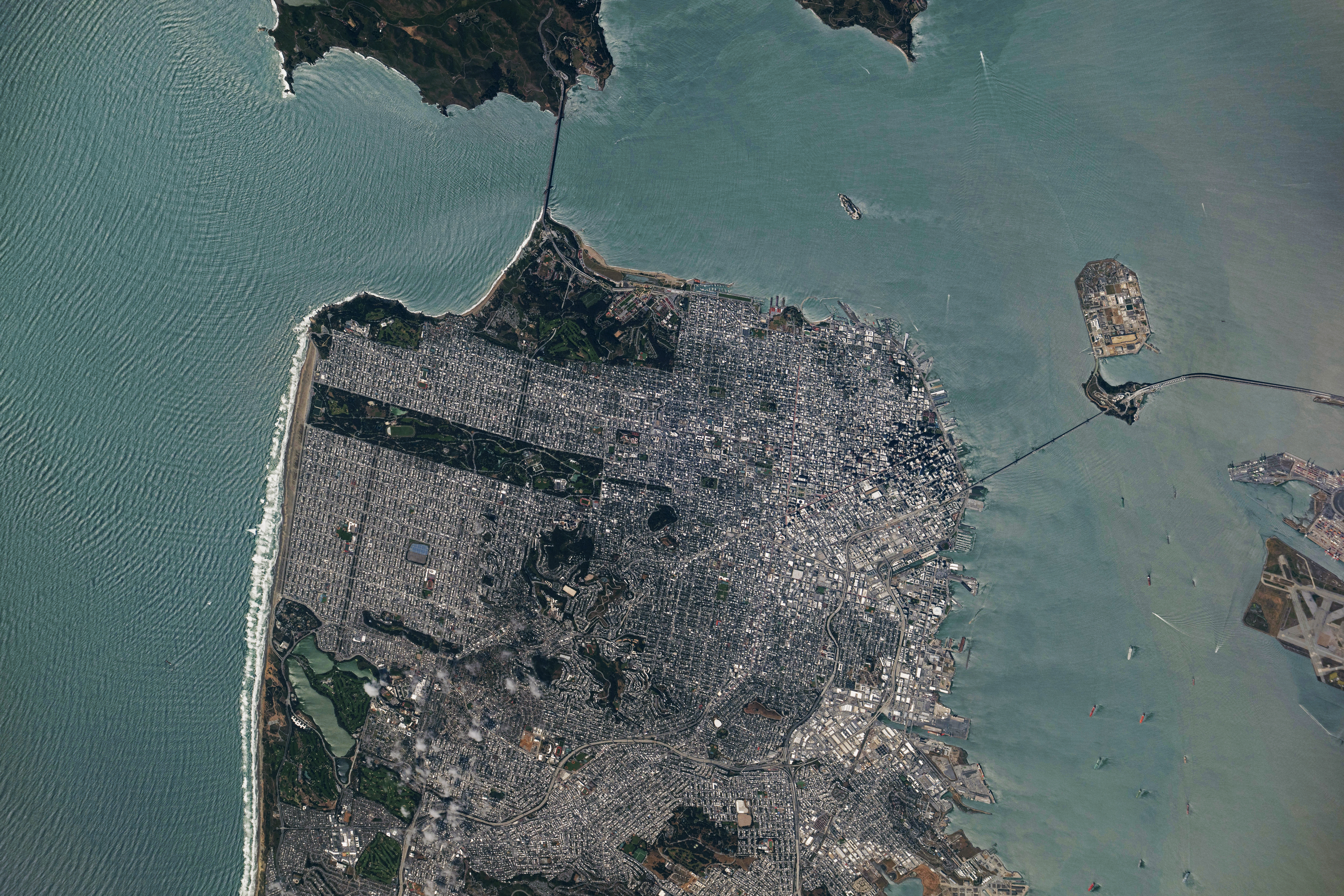 A view of downtown San Francisco from the International Space Station. The city's streets are visible in the daylight, as well as the Golden Gate Bridge to the north and the San Francisco-Oakland Bay Bridge connecting to Oakland to the east.