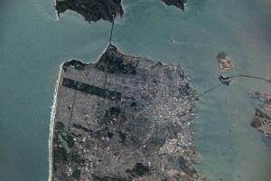 A view of downtown San Francisco from the International Space Station. The city's streets are visible in the daylight, as well as the Golden Gate Bridge to the north and the San Francisco-Oakland Bay Bridge connecting to Oakland to the east.
