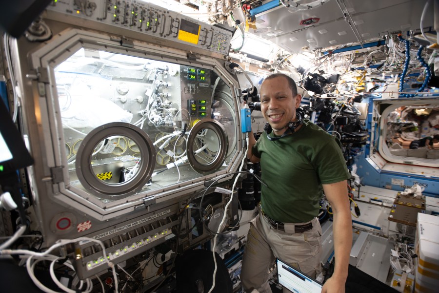 NASA astronaut and Expedition 74 flight engineer Chris Williams shows off the Destiny laboratory module’s Microgravity Science Glovebox aboard the International Space Station. WIlliams was supporting semiconductor crystal research to help advance the commercial space economy and promoting Earth-based industries.