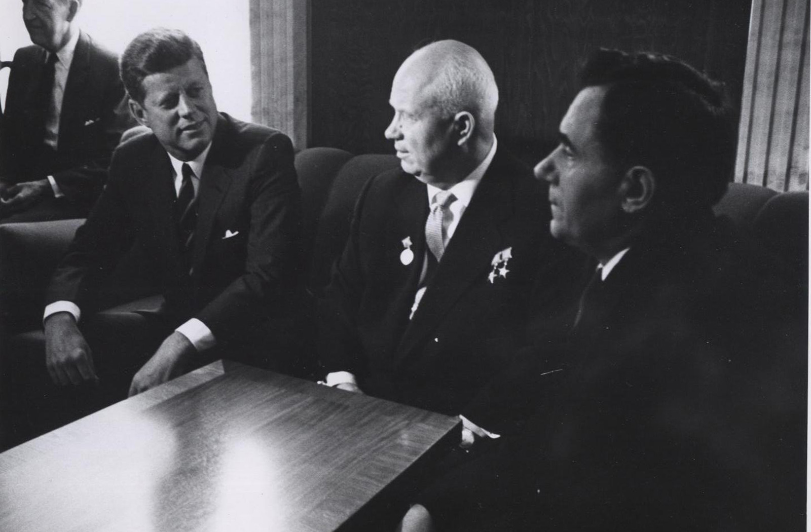President John F. Kennedy sits alongside Nikita Krushchev at a table.