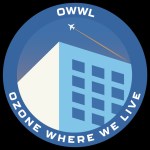 A round project logo in a color-blocked style: the background is a dusty blue, with words in a circle around the edge: OWWL on top and OZONE WHERE WE LIVE on the bottom. In the middle is a building at an angle, with the shaded side in light blue. Above the building a tiny white airplane flies from left to right.