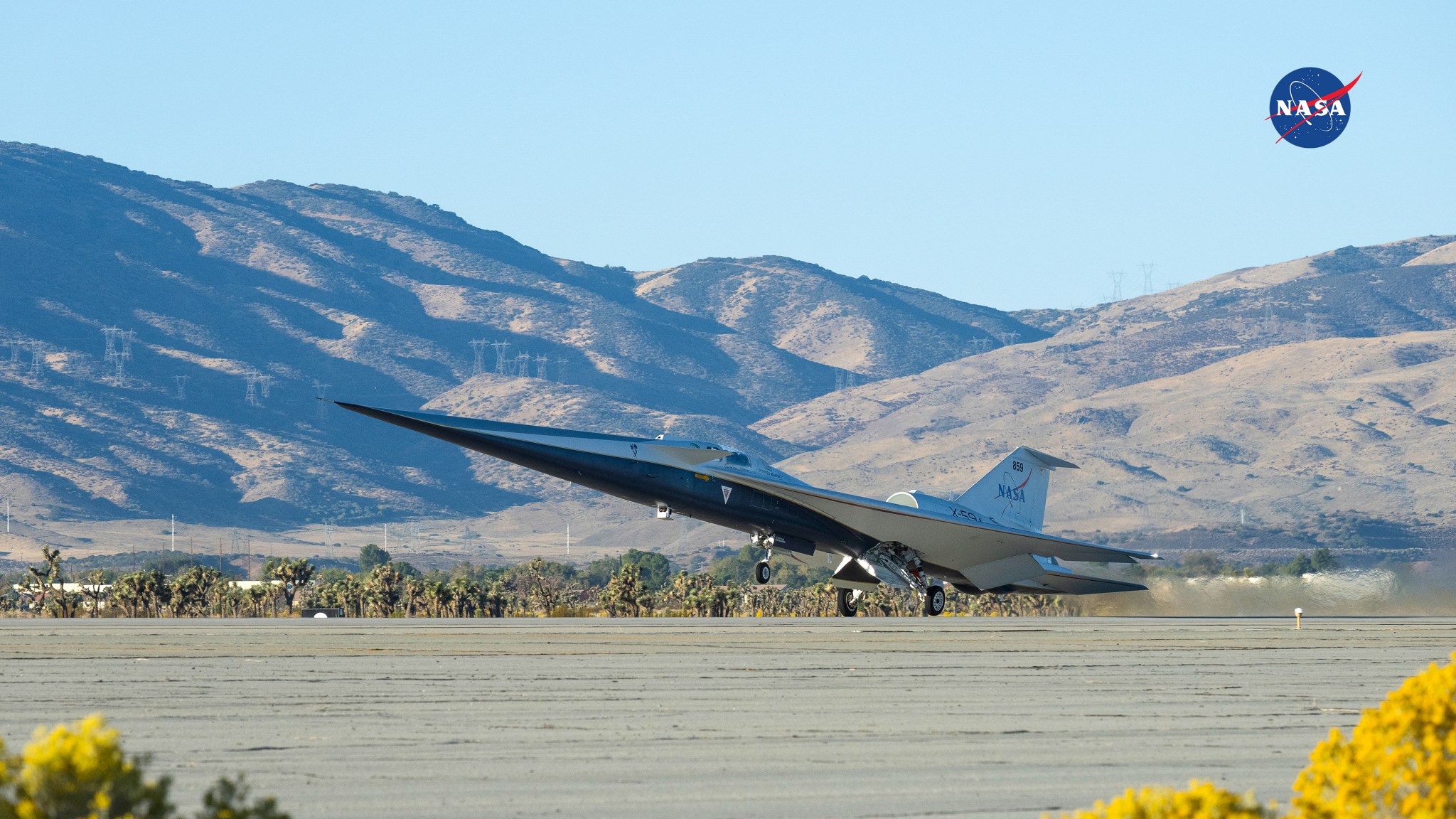 NASA’s X‑59 lifts from the runway on its first flight, with a desert landscape in the background.