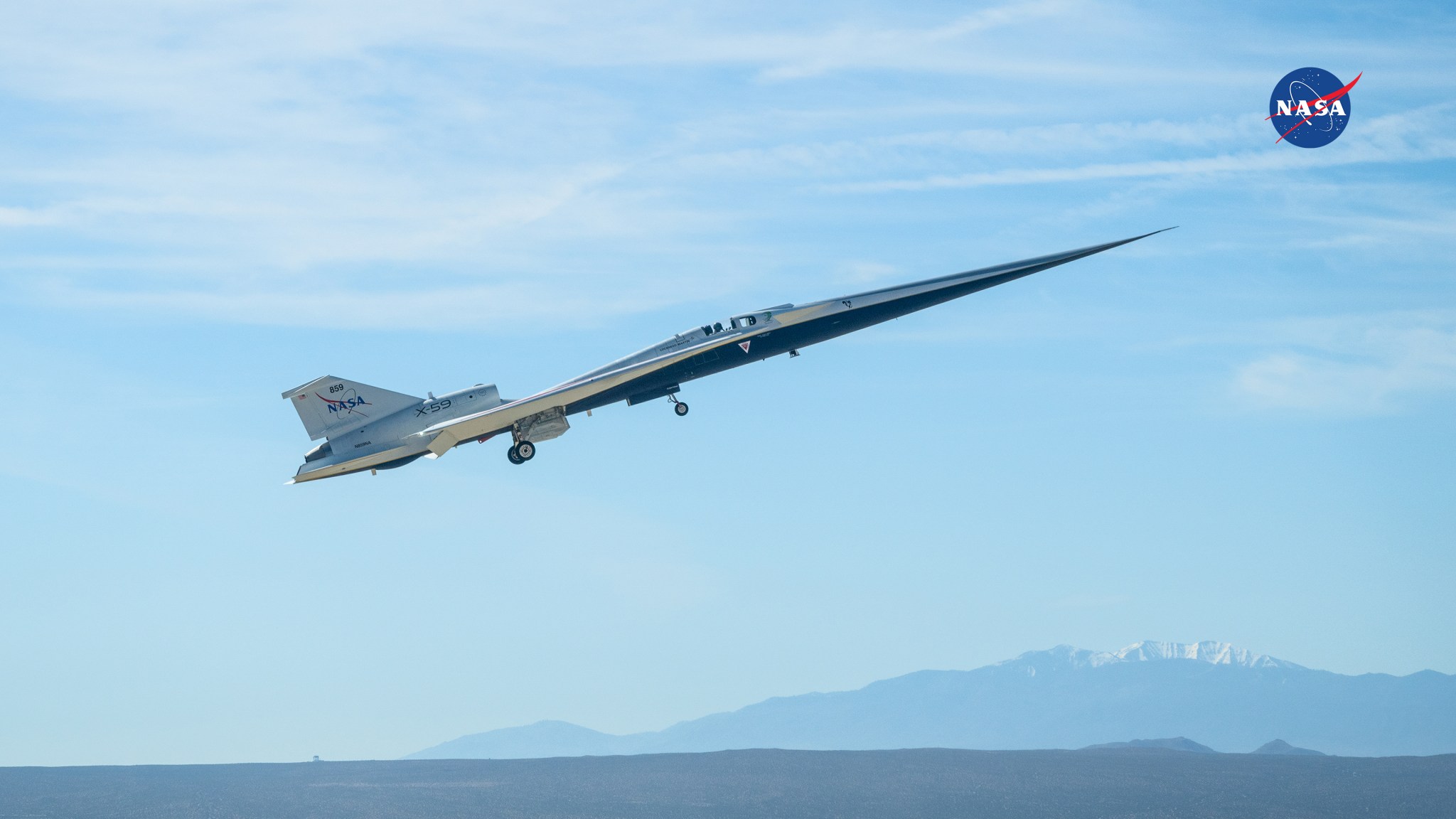NASA’s X-59 takes off during its third flight with mountains in the distance.