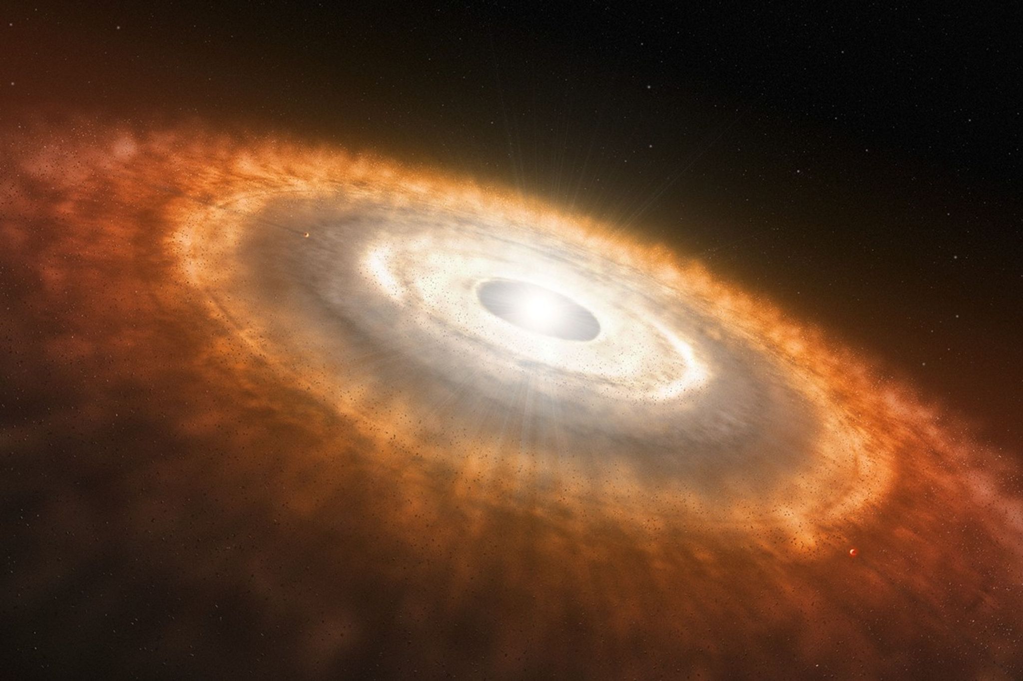 This is an artist’s impression of a young star surrounded by a protoplanetary disk. Darker rings in the disk are where objects like planetesimals are forming, clearing a path through the debris.