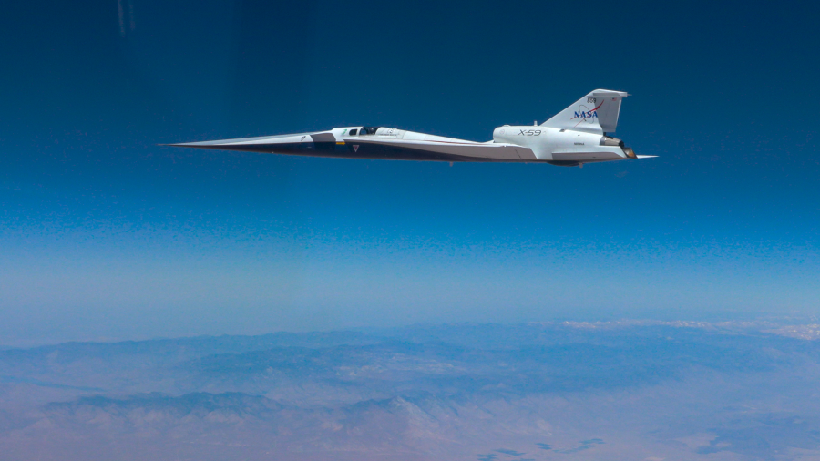 NASA’s X-59 quiet supersonic research aircraft flies above the clouds during its first supersonic flight. The aircraft is shown in side profile during level flight with desert and mountain terrain visible below.