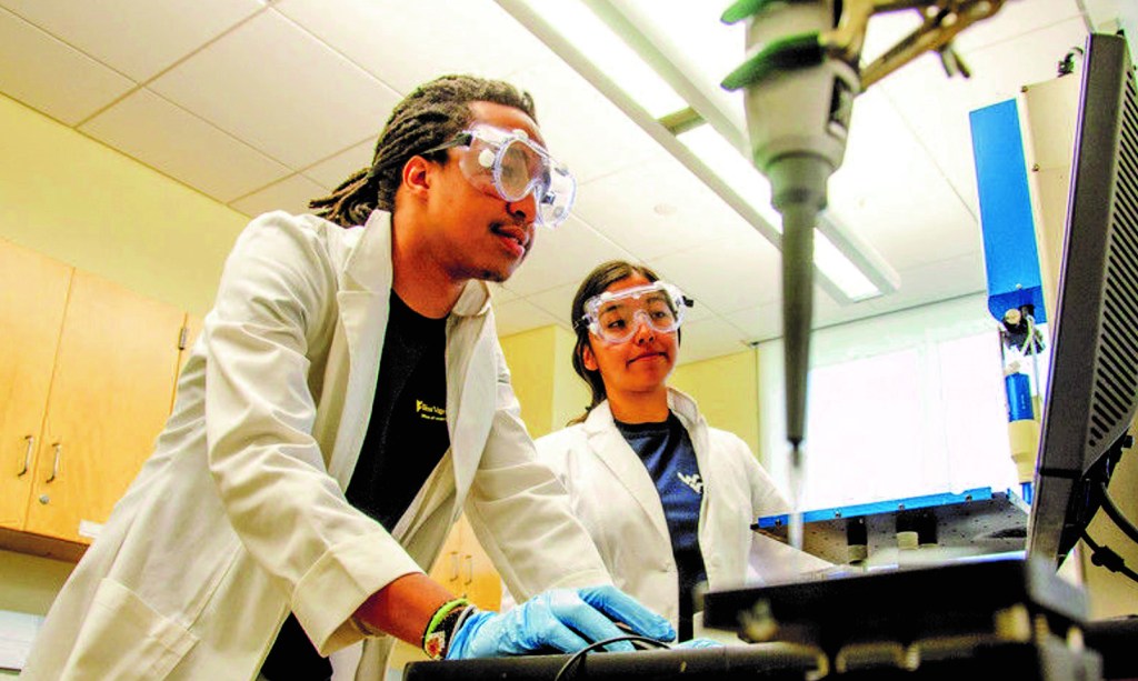 Two students operating a 3D printer.