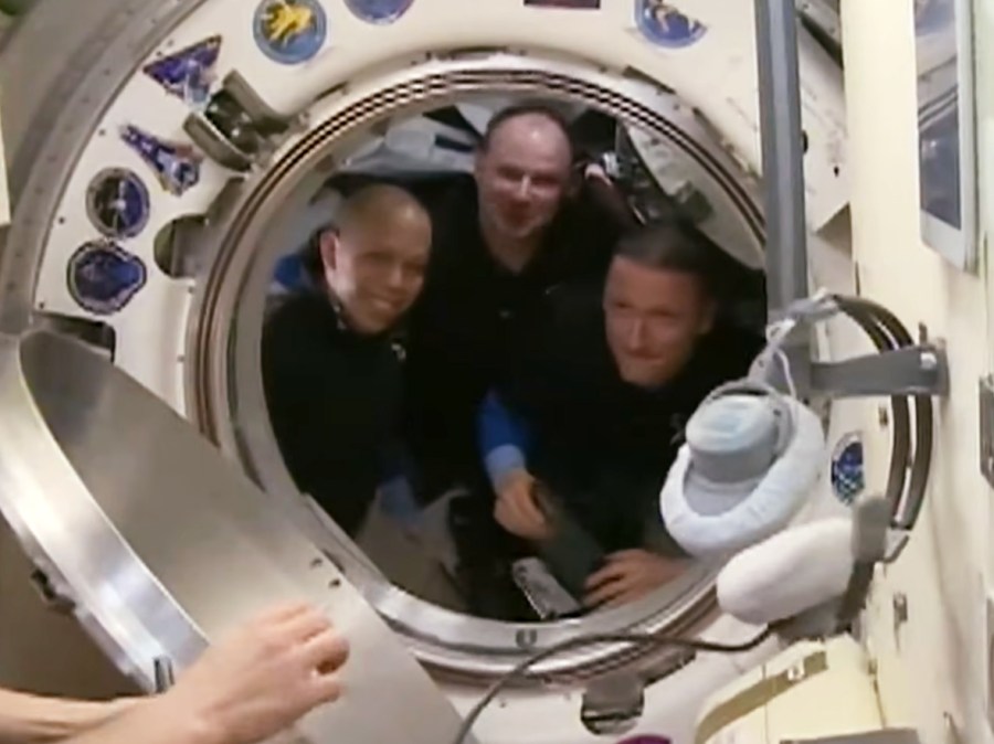 Soyuz MS-28 crew members (from left) Chris Williams of NASA and Roscosmos cosmonauts Sergei Mikaev and Sergey Kud-Sverchkov say farewell to their crewmates before closing the hatch to the Soyuz MS-28 spacecraft.