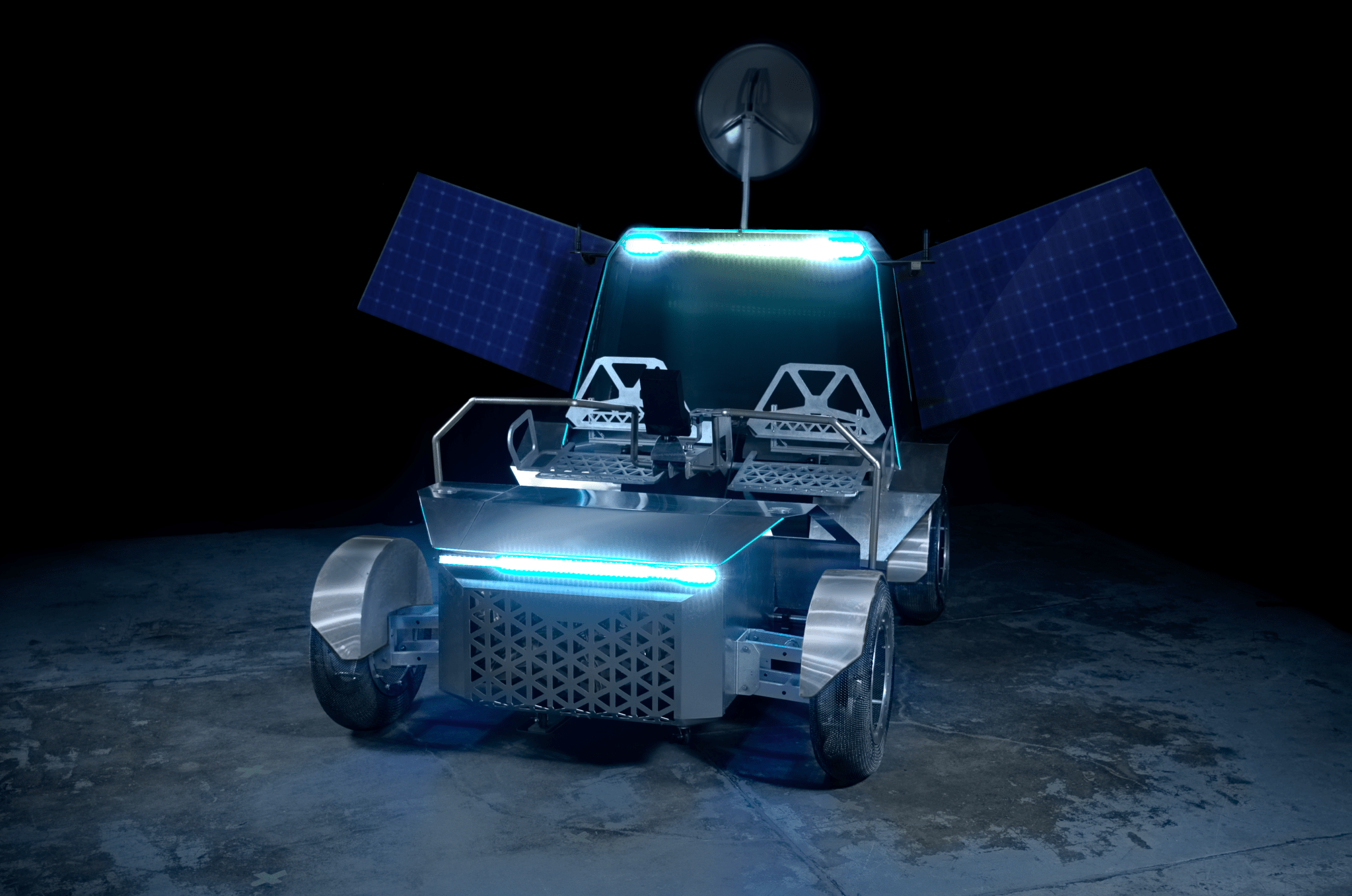 A photo of a full-scale prototype of Lunar Outpost's Pegasus lunar terrain vehicle. The rover can seat two astronauts, is fabricated out of metal, has mesh tires, has two solar arrays deployed, and is lit up by blue lights.