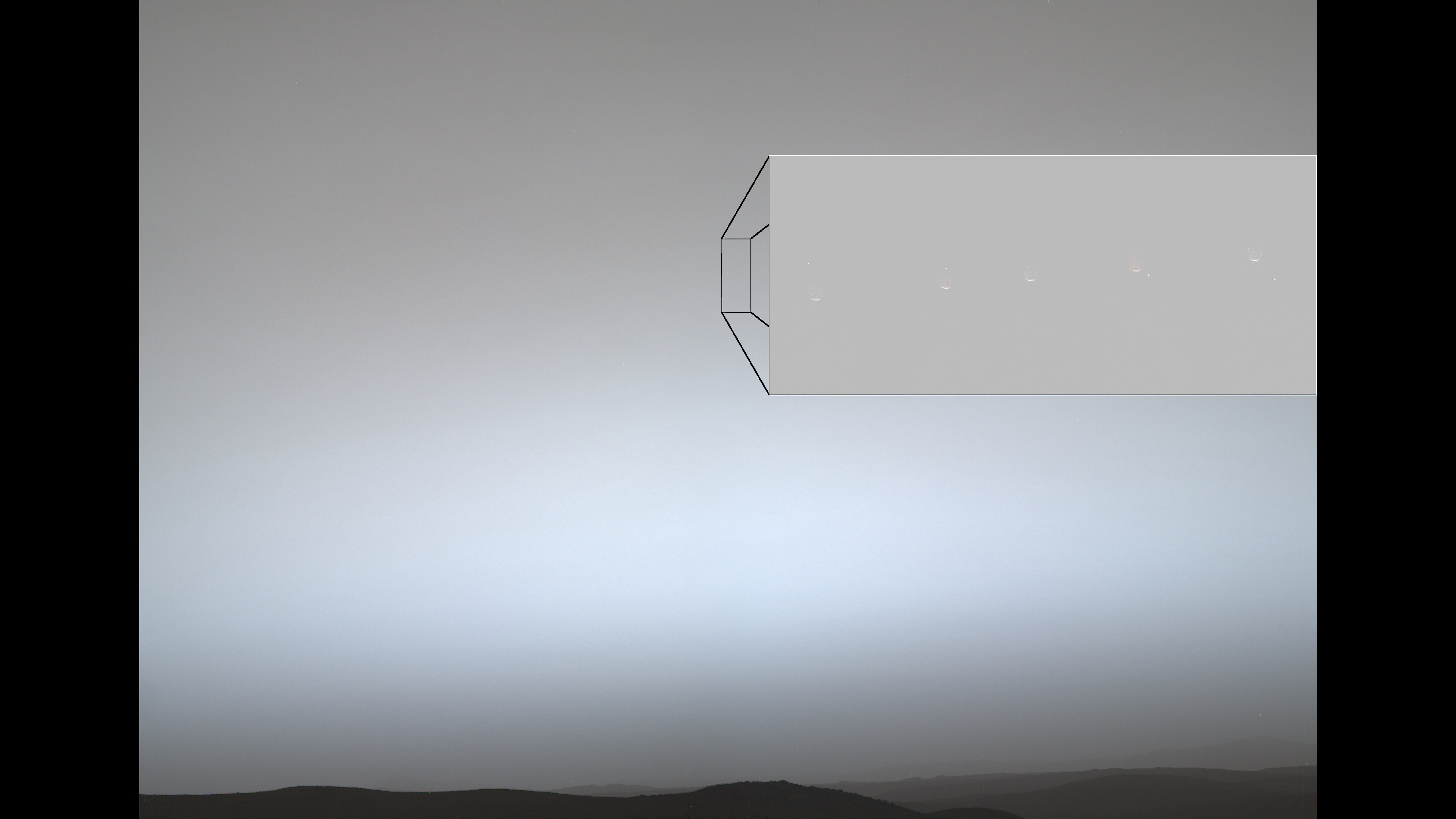 A desolate landscape with a dark horizon sits under a hazy, gray-blue sky. A large rectangular inset in the sky, connected by lines to a smaller rectangle, shows a sequence of five faint crescent shapes with a tiny bright dot moving downward.