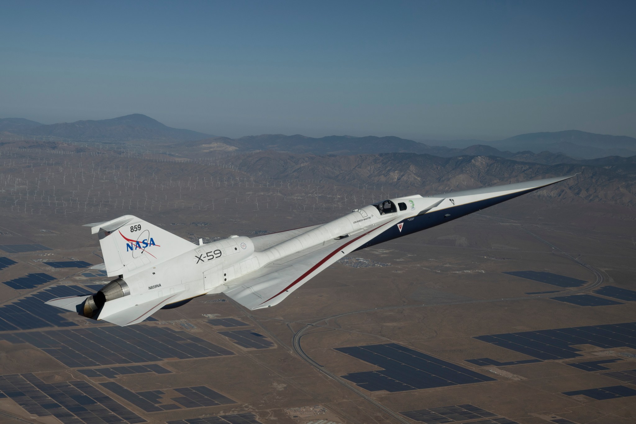 NASA’s white and blue X-59 quiet supersonic research aircraft is shown flying over the desert during a test flight on June 10, 2026.