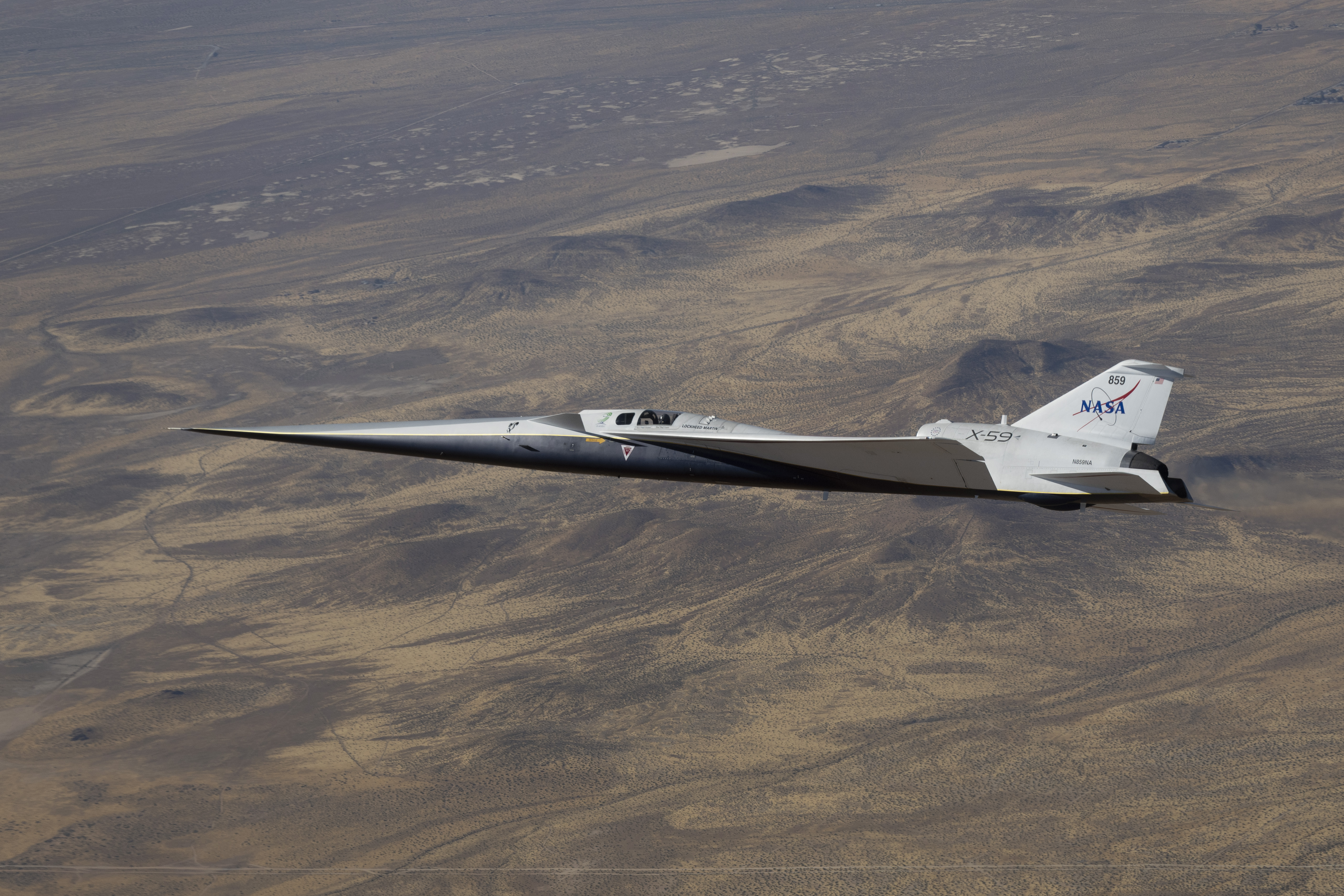 NASA’s white and blue X-59 quiet supersonic research aircraft is shown flying over the desert during a test flight on June 10, 2026.