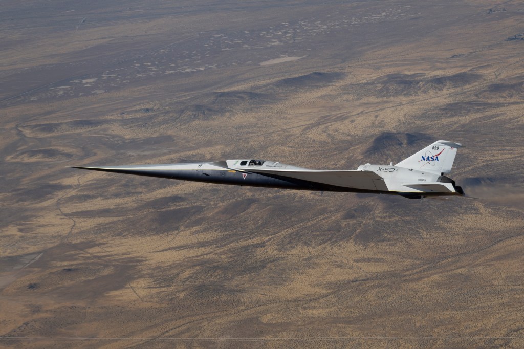NASA’s white and blue X-59 quiet supersonic research aircraft is shown flying over the desert during a test flight on June 10, 2026.