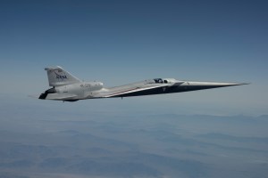 NASA’s white and blue X-59 quiet supersonic research aircraft is shown in profile against a blue sky during a test flight on June 10, 2026.