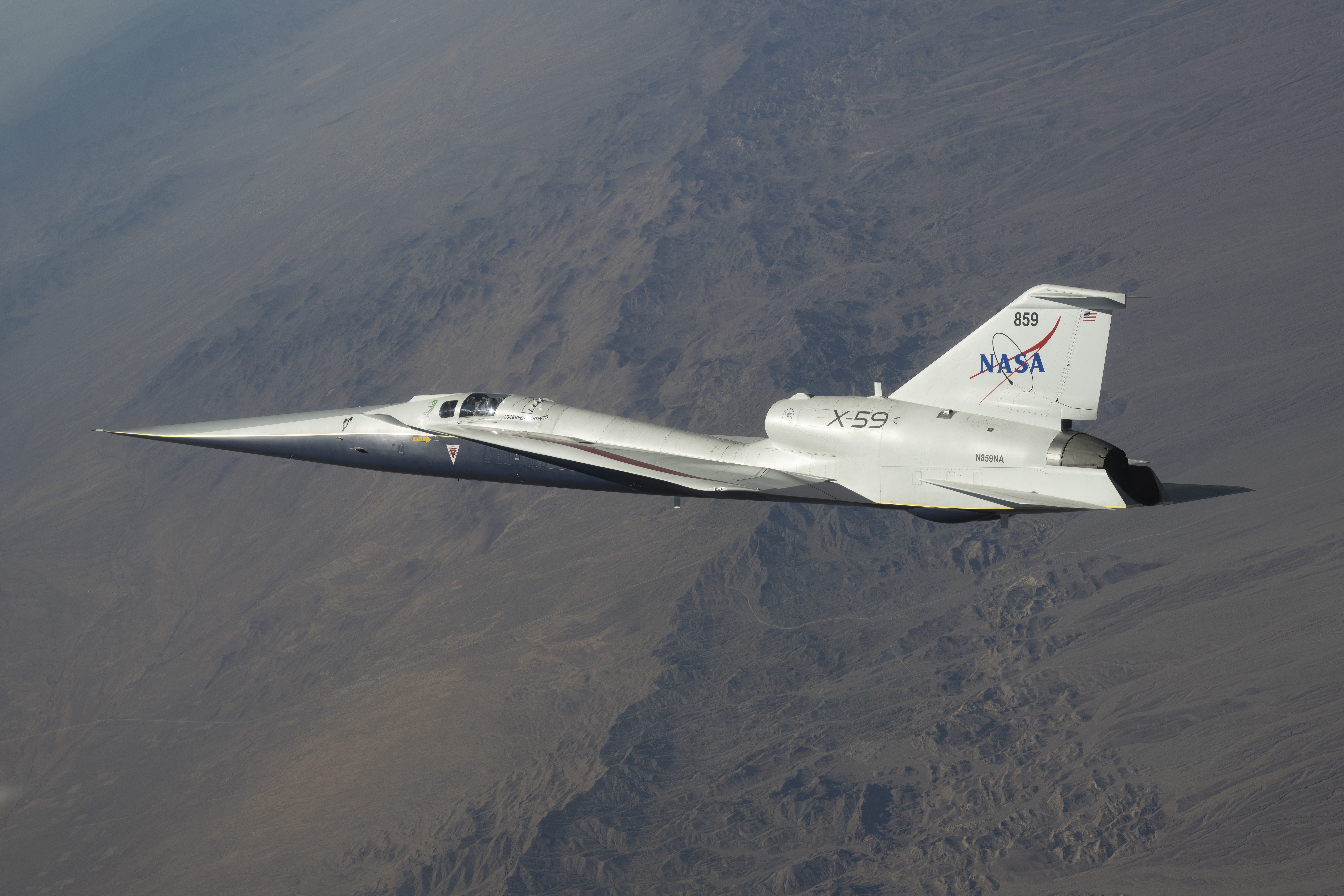 NASA’s white and blue X-59 quiet supersonic research aircraft is shown flying over the desert during a test flight on June 10, 2026.