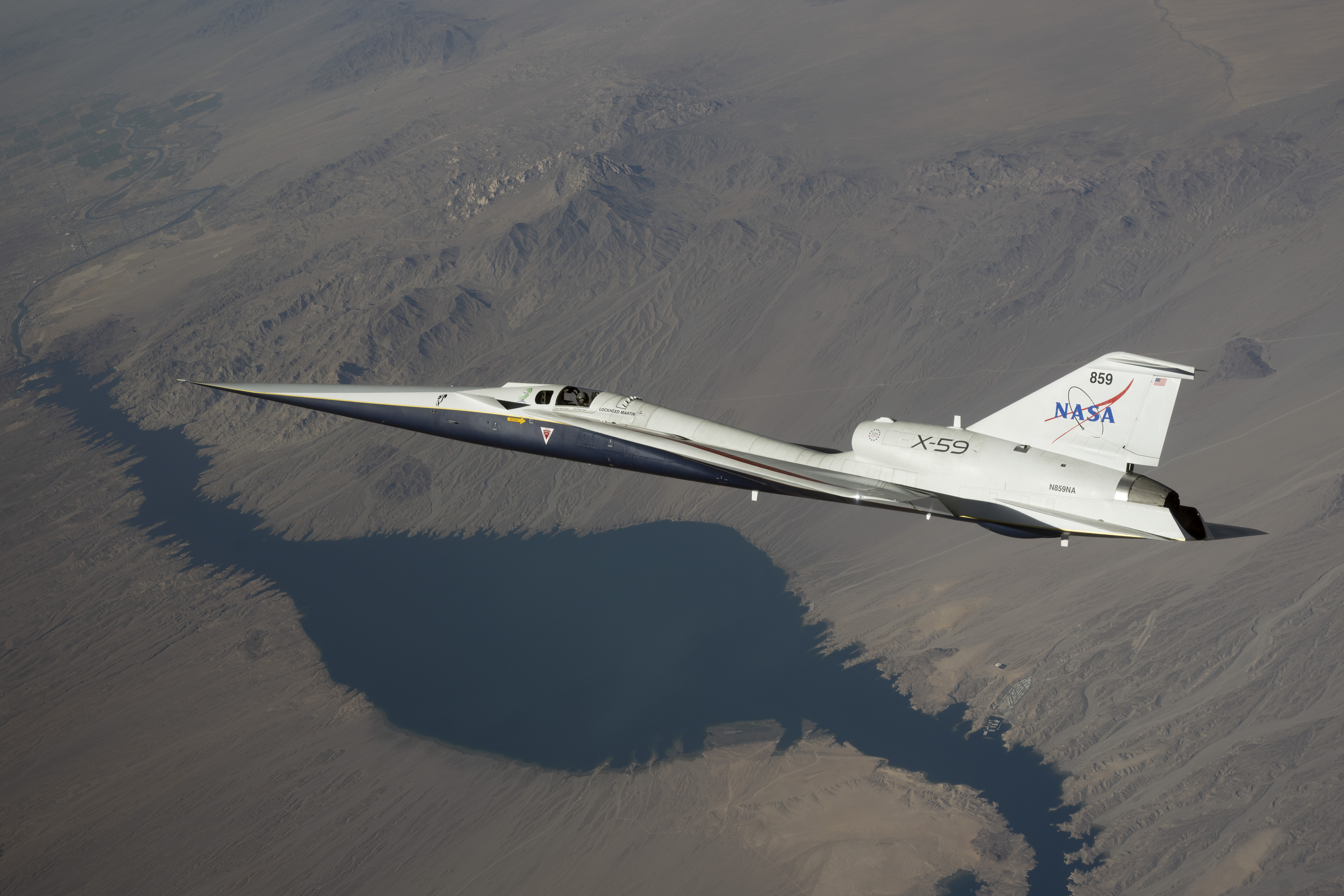 NASA’s white and blue X-59 quiet supersonic research aircraft is shown flying over the desert during a test flight on June 10, 2026.