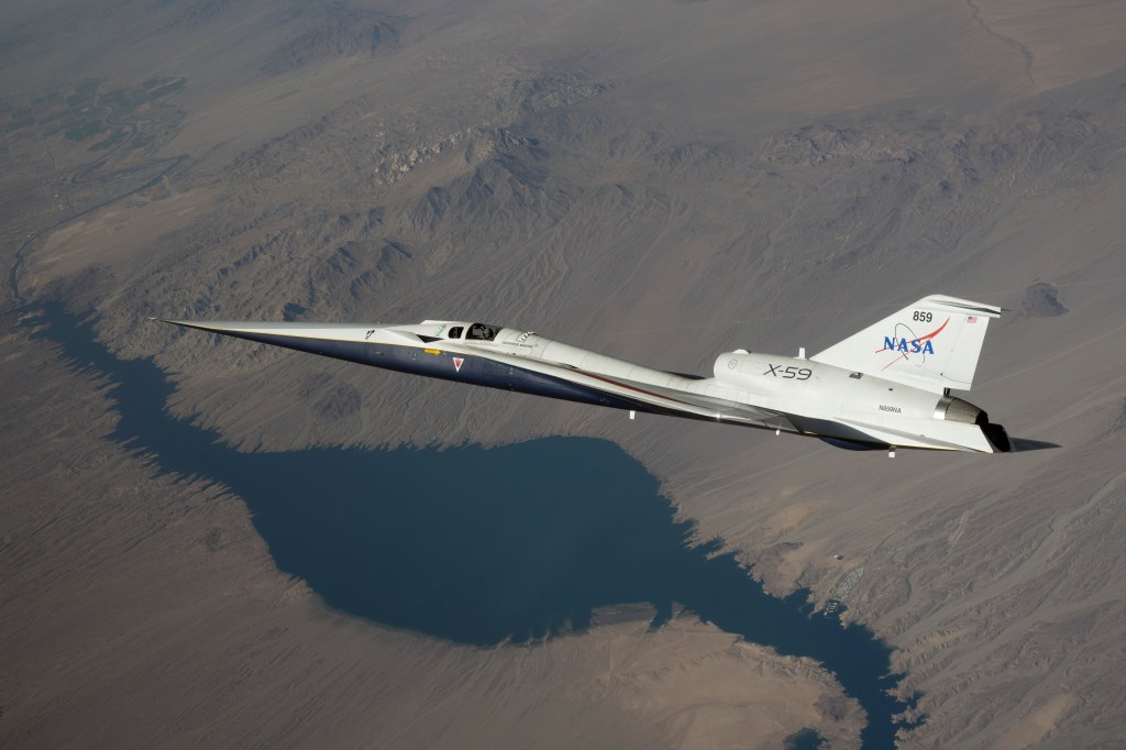 NASA’s white and blue X-59 quiet supersonic research aircraft is shown flying over the desert during a test flight on June 10, 2026.