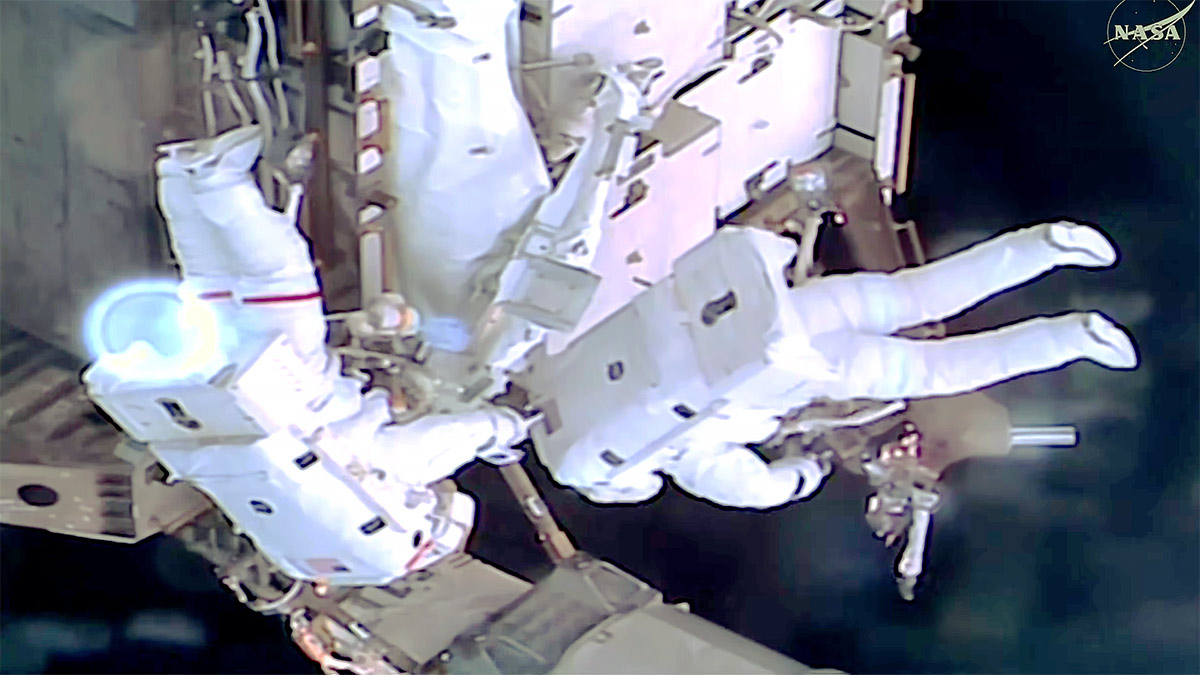 From left, NASA astronauts Jessica Meir and Anil Menon work outside the International Space Station during a spacewalk to install hardware for future power system upgrades.