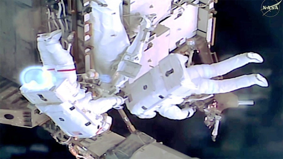 From left, NASA astronauts Jessica Meir and Anil Menon work outside the International Space Station during a spacewalk to install hardware for future power system upgrades.