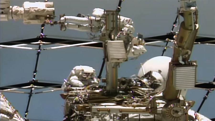 From top, Astronauts Anil Menon of NASA and Sophie Adenot of ESA (European Space Agency) work on a space-to-ground antenna outside the International Space Station.