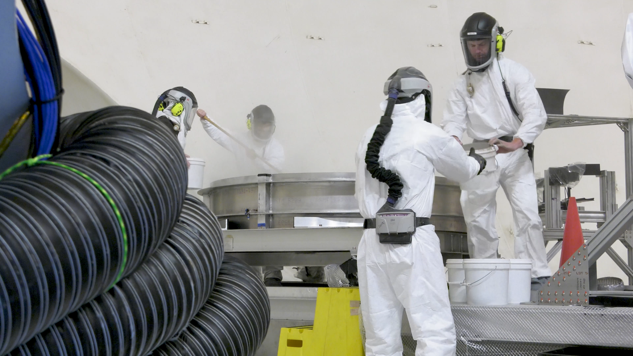 A crew loads simulated lunar dirt into the test bin in the 60' vacuum sphere.