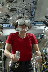 NASA astronaut Jessica Meir wears a VR set with goggles and two controllers.
