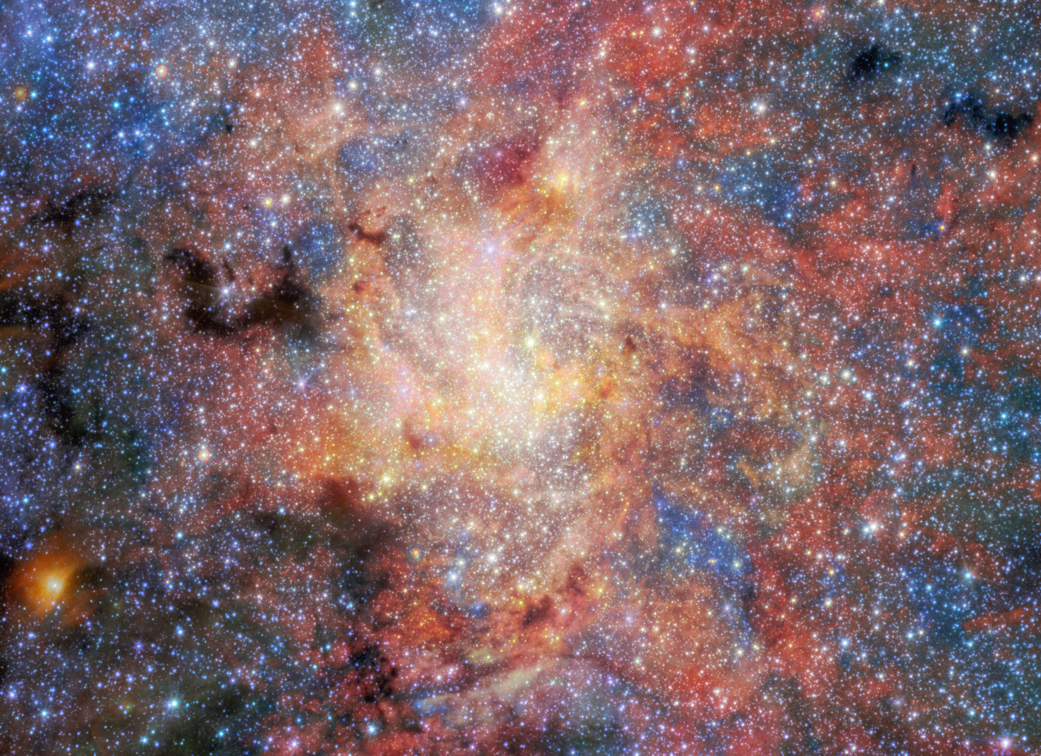 A dense star field fills the entire image, with countless stars scattered across a backdrop of glowing clouds in shades of red, orange, pink, white, and blue. At the center, a brilliant concentration of stars creates a bright, almost white core surrounded by intricate filaments and wisps of illuminated gas and dust that radiate outward. Dark, irregular patches of opaque dust interrupt the glowing clouds, particularly toward the left side of the image, where they appear as silhouetted shapes against the brighter background. The surrounding stellar population varies in brightness and color, with cool blue stars and warmer orange and red stars distributed throughout the scene.