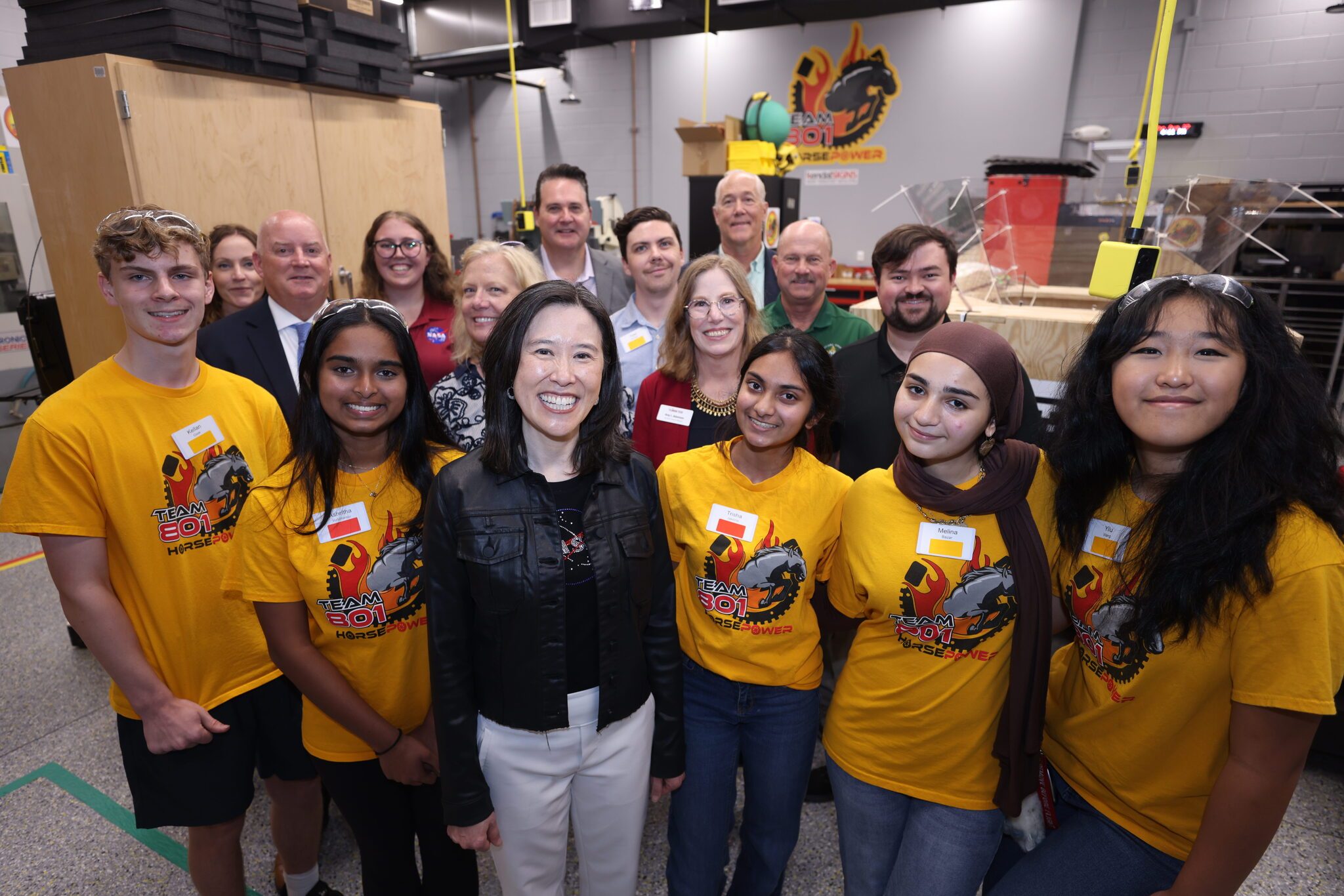 A group of students posing with Elaine Ho wearing matching t-shirts
