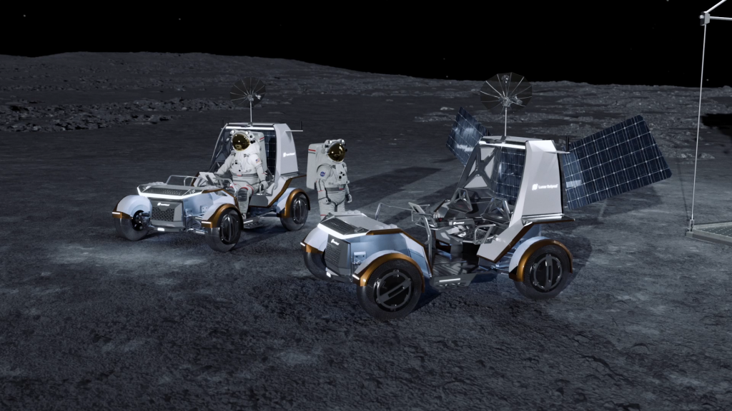 A rendering of two Lunar Outpost lunar terrain vehicles on the lunar surface. Both vehicles are white and silver with bronze coverings on the wheels and are facing to the left. An astronaut in a white suit sits in the driver seat of the left vehicle which also hosts a black circular antenna attached to the top. Another astronaut stands between the two vehicles. The vehicle on the right has a circular antenna on top as well as solar panels flaring out to either side of the vehicle. To the right of the image a metal frame is visible. The vehicles are sitting on the lunar surface below the black vastness of space.