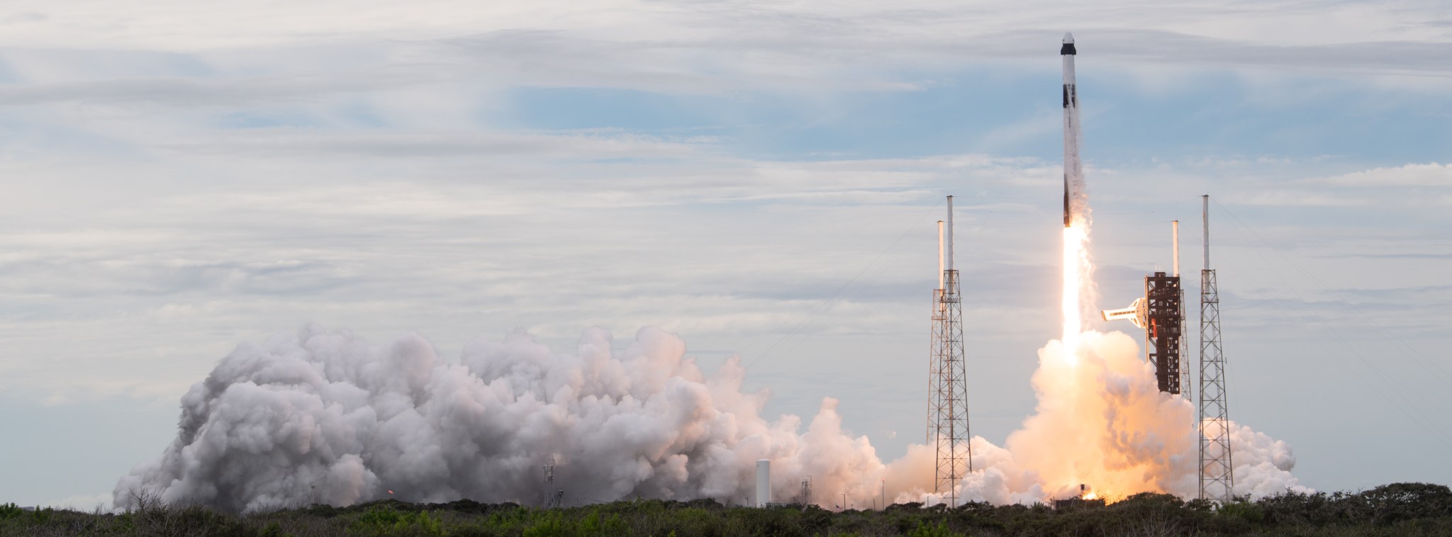Rocket launches with fire and smoke trailing behind it.