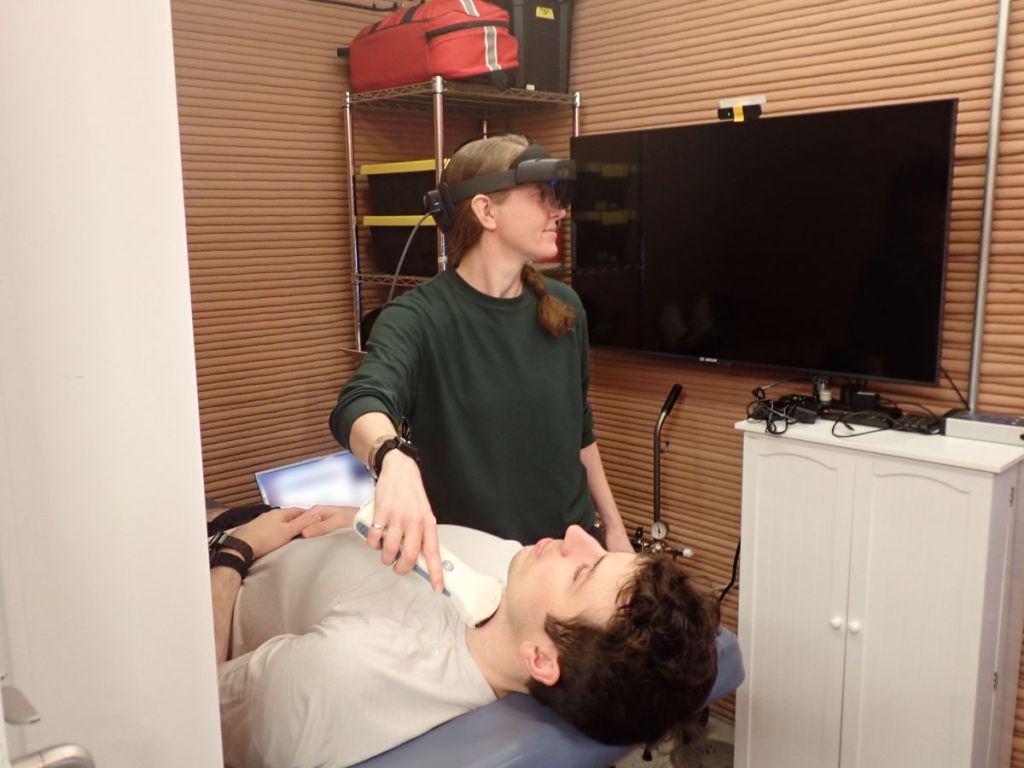Ellen Ellis, CHAPEA Mission 2 medical officer, performs a medical task with Ross Elder, mission commander.