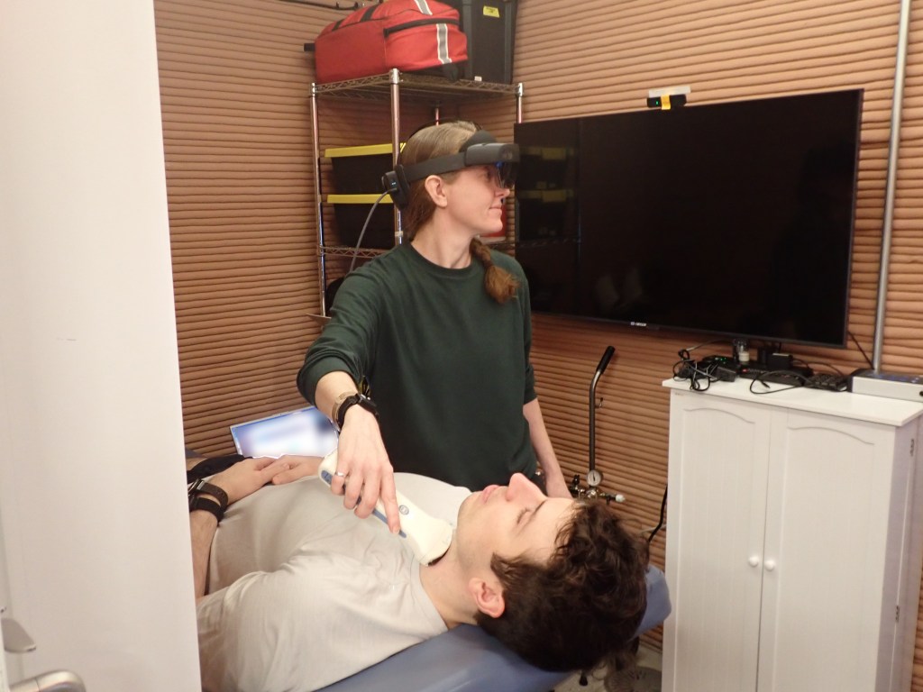 Ellen Ellis, CHAPEA Mission 2 medical officer, performs a medical task with Ross Elder, mission commander. Credit: NASA