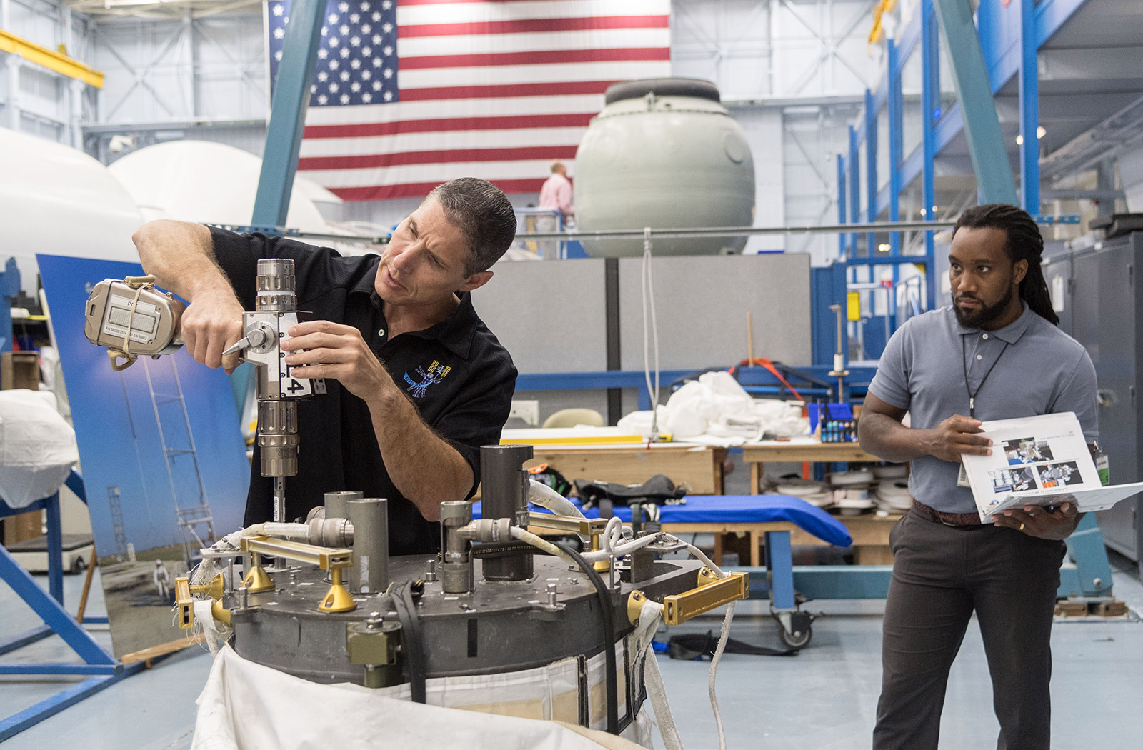 Astronaut training with tools for space station.