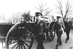 soldiers escorting flag draped coffins to cemetary