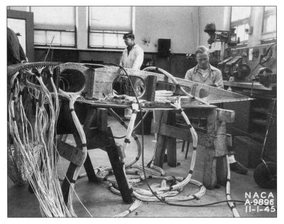 Technicians install thermocouples and nichrome electrical heating strips on a test airfoil.