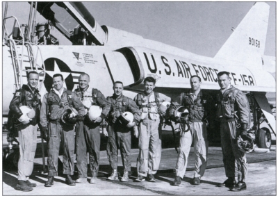 Photo of The Mercury Seven astronauts standing in front of a Jet.
